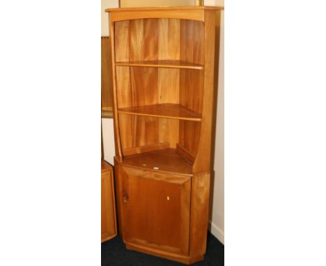 Ercol light oak corner unit fitted with three shelves over cupboard door base. 179cm x 72cm wide.