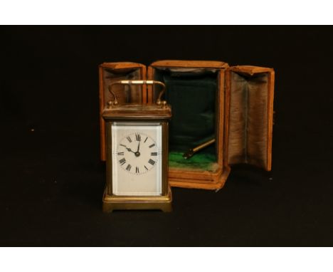 French carriage clock striking on a coiled gong in typical corniche case with outer leather carrying case, 11cm tall.