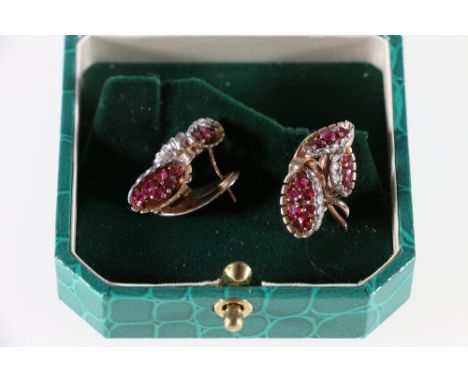 18ct yellow and white gold ruby and diamond set floral earrings. Mid 20th century. three flower heads at varying angles, outl