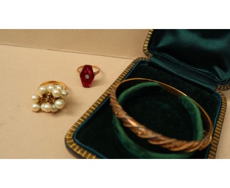 A 15ct gold hinged bangle decorated with beads and leaves, approximately 9 grams, together with a diamond set panel ring and 