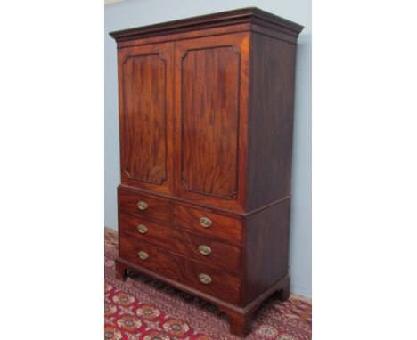 A 19th century mahogany linen press with a moulded cornice above a pair of panelled doors enclosing linen slides, the base wi