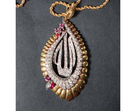A diamond and ruby "Allah" pendant set with four round faceted rubies two pointed oval rubies and various sized round brillia