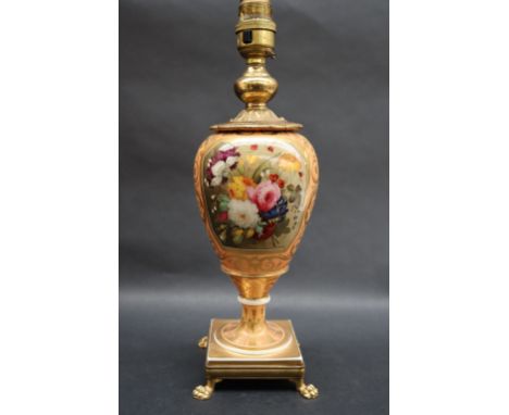 A 19th century porcelain vase converted to a table lamp painted with a spray of garden flowers to an orange ground with gilt 