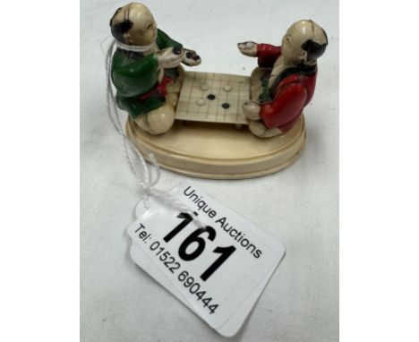 An ivorex figure group of two Chinese men playing a board game.
