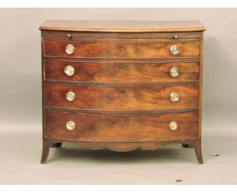 A George III bow fronted mahogany dressing chest, brushing slide over four graduated long drawers, on out splayed bracket fee