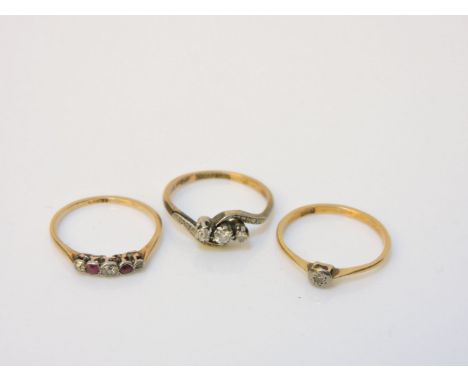 A three stone diamond crossover ring, marked 18ct and plat, a gold five stone diamond and ruby ring marked 18ct, and a single