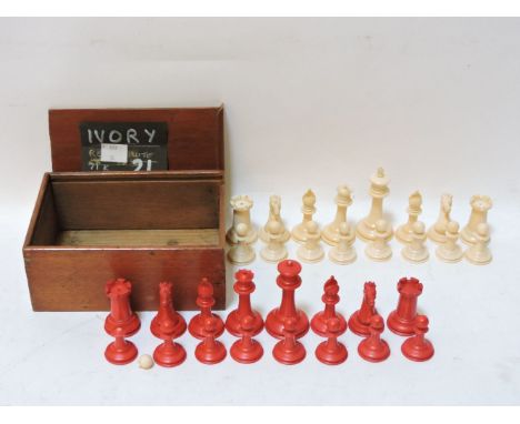 A Staunton pattern natural and stained ivory chess set, c1920, a knight and rook from each side impressed with black crown, K