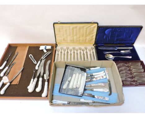 A collection of pottery and porcelain, knife handles, with damage, three boxed cutlery sets, and a wicker picnic hamper with 