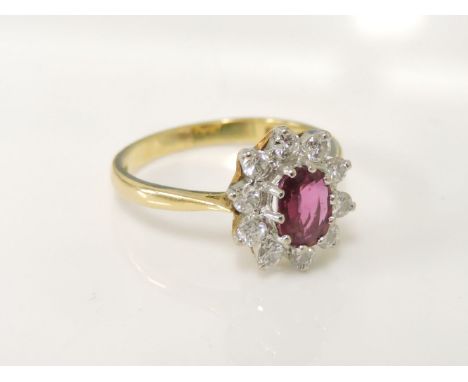 A 18ct gold oval cut ruby and diamond cluster ring