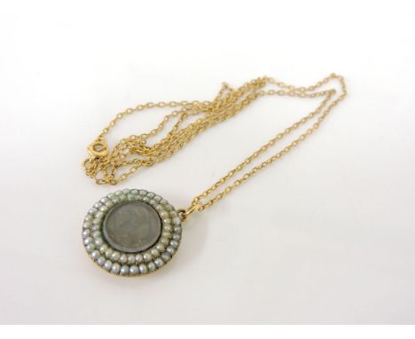 A gold memorial two row split pearl pendant, the centre with a lock of plaited hair and engine turned decoration to the rever
