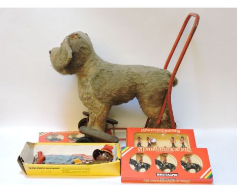 A Lines Bros push along dog, A/F, a Pelham puppet, and three modern boxes of Britains Bandsmen, Mounties and Life Guards