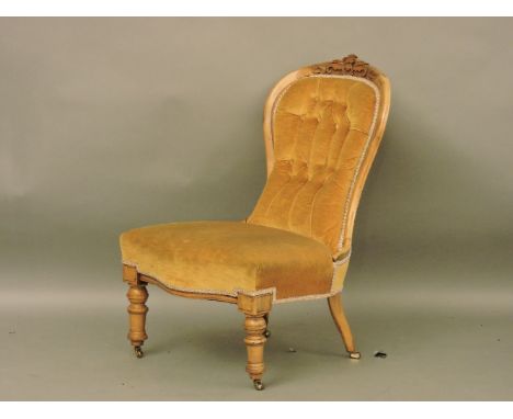 A Victorian walnut spoon back nursing chair, with yellow Draylon button upholstery