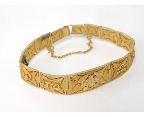 A gold zodiac graduated filigree panel bracelet, tested as approximately 9ct gold