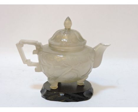An agate teapot, 20th century, carved with a lotus pond on three feet, 9cm high, to top of finial