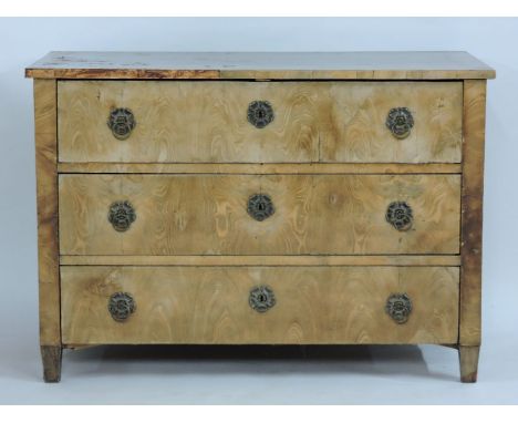 An Austrian, possibly elm commode chest, of three graduated long drawers with floral escutcheons and standing on short taperi