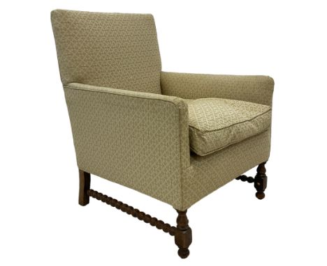 Early 20th century upholstered armchair, on turned front feet united by bobbin turned stretchers, upholstered in Zoffany fabr