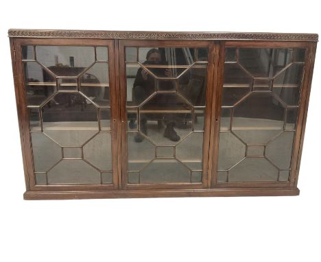 Early 20th century Georgian design enclosed bookcase, the blind-fretwork frieze in the form of repeating Vitruvian waves, fit