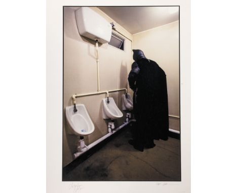 An original print of a photograph taken by set photographer Stephen Vaughan of Batman (Christian Bale) using a urinal from Ch