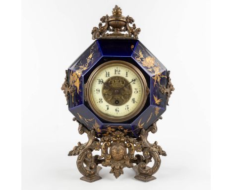 A mantle clock, glazed ceramics and mounted with patinated bronze. 19th century.&nbsp;Dimensions:(D:11 x W:26 x H:38 cm)