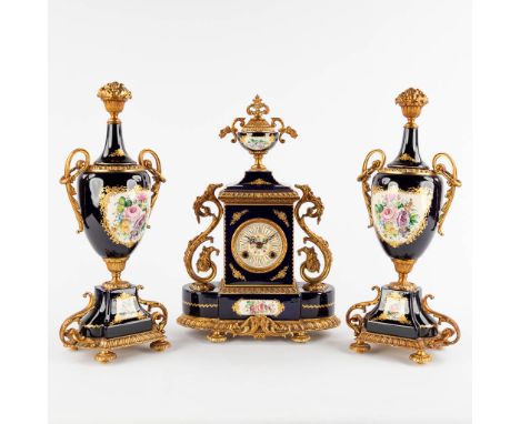 A.C.F. A three-piece mantle garniture clock and side pieces, cobalt blue porcelain mounted with bronze.Finished with floral d