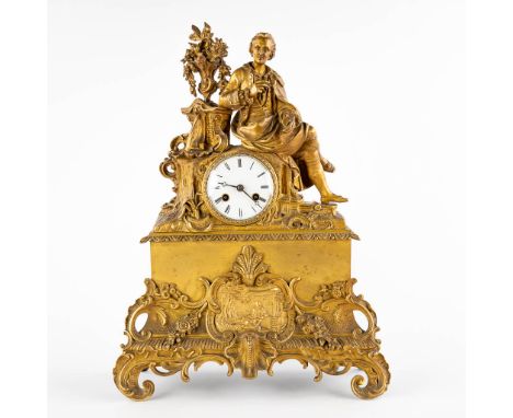 A mantle clock, gilt bronze with an image of a man taking notes.France, 19th century.&nbsp;Condition: - Missing the bell, pen