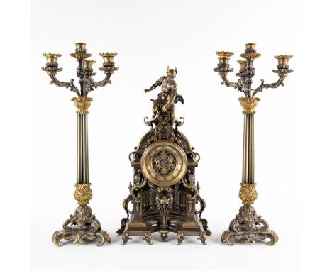 A three-piece mantle garniture clock and candelabra. Clock with an image of Mercury/Hermès.Patinated and gilt bronze. 19th ce