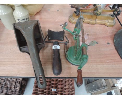 A collection of vintage kitchen tools including rolling biscuit cutter, potato ricer and apple pealer