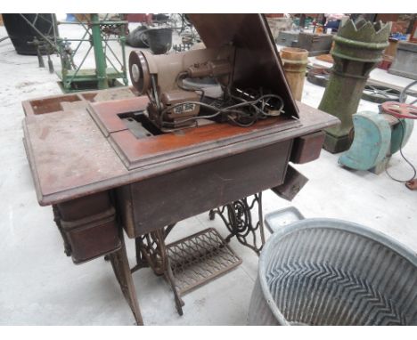 A Singer electric sewing machine on a vinrage folding treddle table