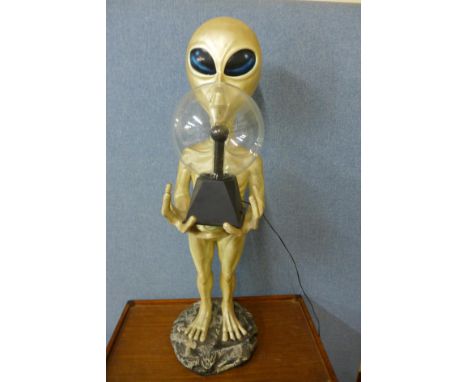 A floor standing an alien holding spherical lamp, total height - 97cms. 