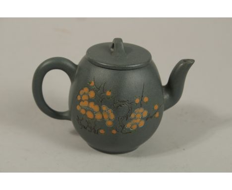 A SMALL CHINESE GREEN YIXING TEAPOT, with carved flora and calligraphy, the base with impressed character mark, 8cm high.