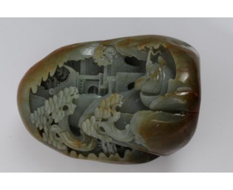 Large Chinese carved russet jade / green hardstone boulder in the form of a mountainous landscape with pine trees and pavilli