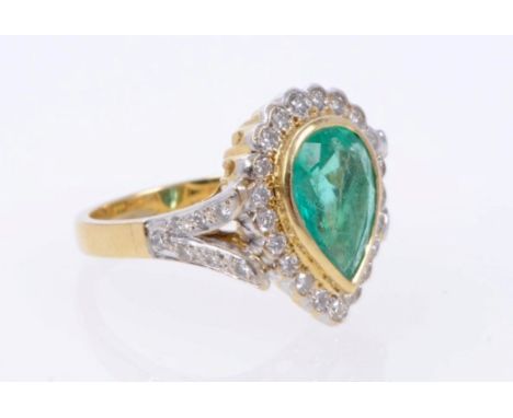 Gold (18ct) emerald and diamond cluster ring with a pear cut emerald surrounded by a border of brilliant cut diamonds, with d