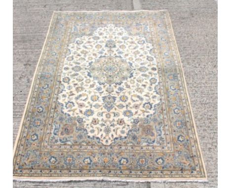 Kashan rug, the light mustard field with central pendant medallion and allover scrolling arabesque floral ornament within con