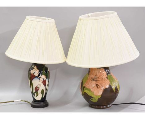A Moorcroft Pottery Table Lamp, Hibiscus pattern on a brown ground, together with a further Moorcroft pottery table lamp in t