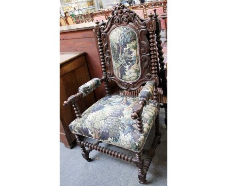 A Victorian Carved Oak Open Arm Hall Chair, decorated with acanthus leaves and bobbin-turned supports, moving on castors