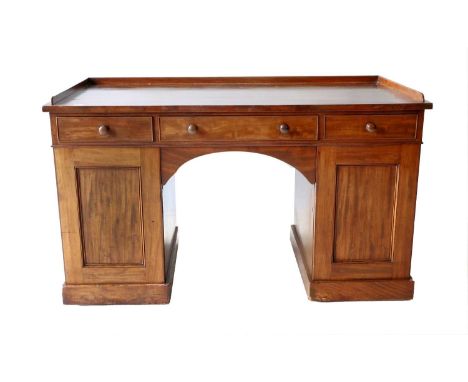 A George IV Mahogany Kneehole Desk, 2nd quarter 19th century, the three-quarter gallery above three mahogany-lined frieze dra