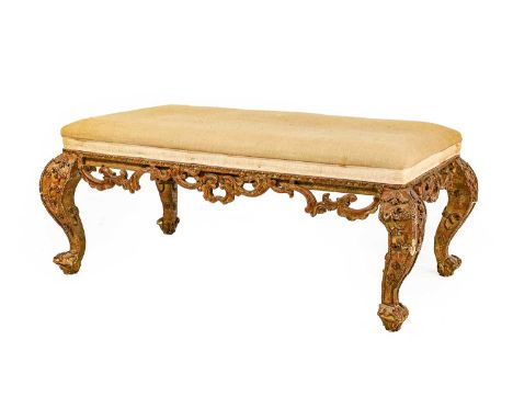 A Victorian Carved Giltwood Oversized Stool, late 19th/early 20th century, recovered in light brown calico, the overstuffed s