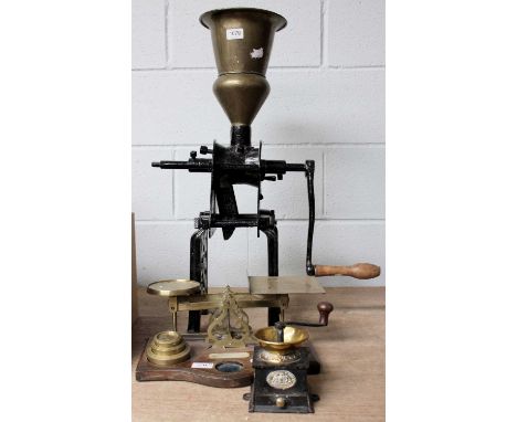 A Large Victorian Bench Top Coffee Grinder, a conical brass hopper and openwork cast iron base; together with a similar small