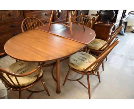 A modern Ercol dining table and six (four plus two) hoop and stick back chairs having crinoline stretchers