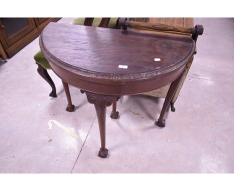 A Victorian mahogany demi-lune card table, of traditional design with moulded and carved foliate details, raised on cabriole 