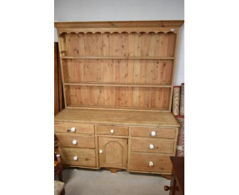 A 19th century pine dresser base, having ceramic handles and later complimentary plate rack, width approx. 165cm, depth 56cm