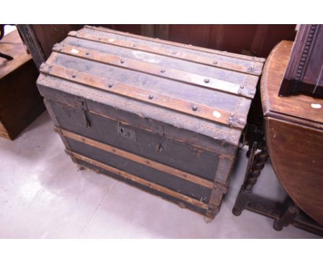 A vintage dome top travel trunk, mounted on castors, width approx. 85cm