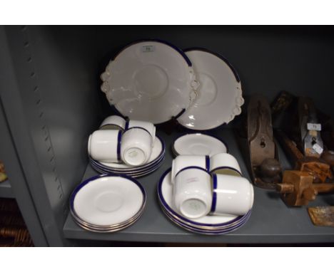 A collection of Tuscan cups and saucers,side plates and cake plates, having white ground with blue band and gilt detailing, a
