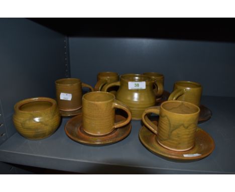 A collection of studio pottery including six cups and saucers,jug and sugar basin.