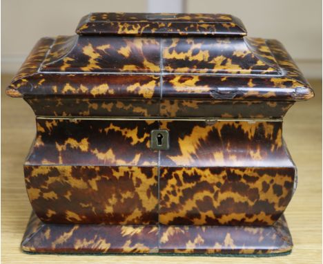 An early 19th century tortoiseshell tea caddy, of shaped sarcophagus form with two-division interior (cover detached and loss