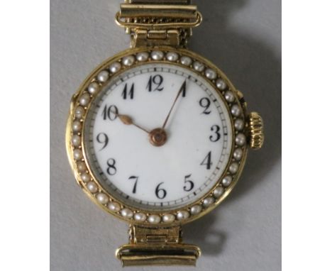 A lady's 18ct gold and split pearl set manual wind wrist watch, on a gold plated mesh bracelet.