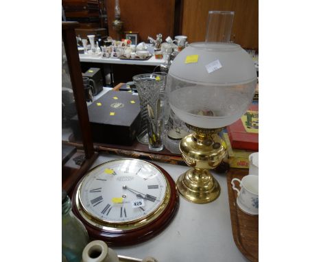 Modern circular wall clock together with a modern oil lamp