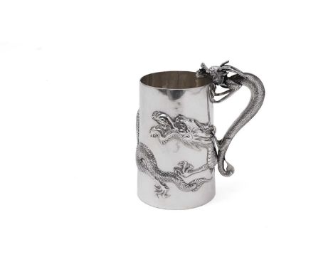 A late 19th /early 20th Century Chinese silver mug, of tapering cylindrical form, with a dragon handle and a dragon in relief