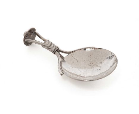A George V arts and crafts silver caddy spoon, with a circular hammered bowl, a bound, wirework stem with a coiled tendril ra