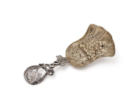 A Victorian silver naturalistic caddy spoon, with a gilt, fun-shaped bowl embossed with fruiting vines and a leaf tendril ste